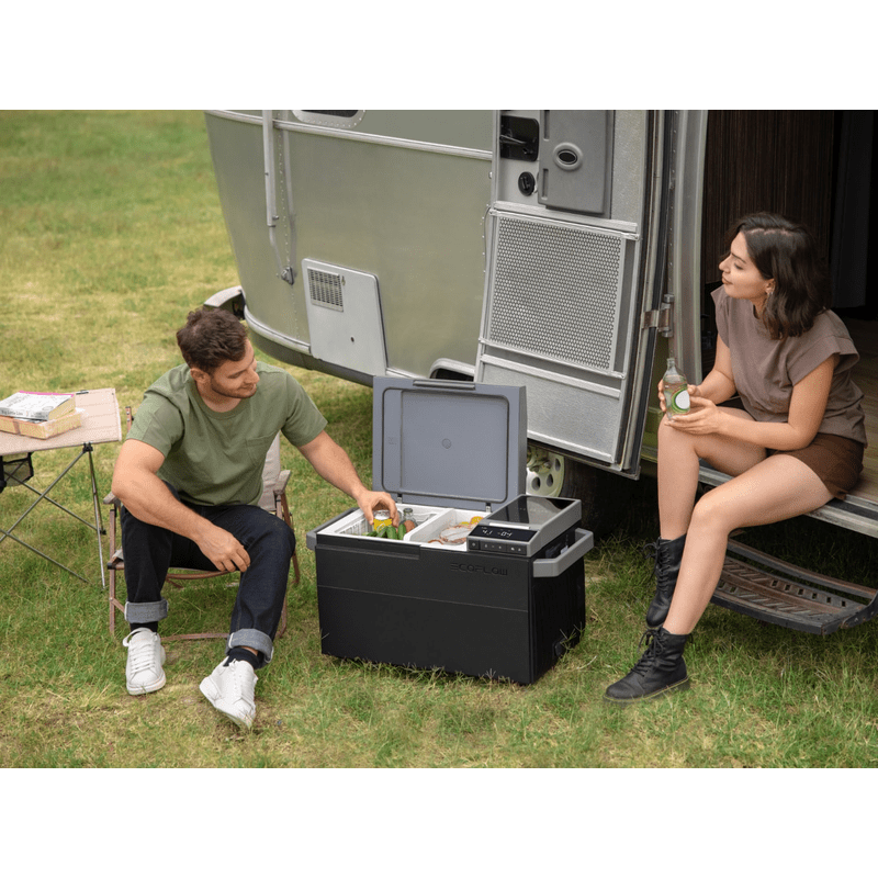 Man and women using camping freezer eco flow glacier while sitting outside of RV
