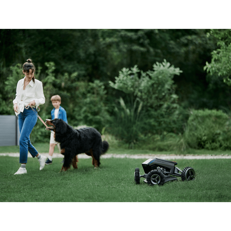 Robotic lawn mower : EcoFlow Blade mowing yard next to family