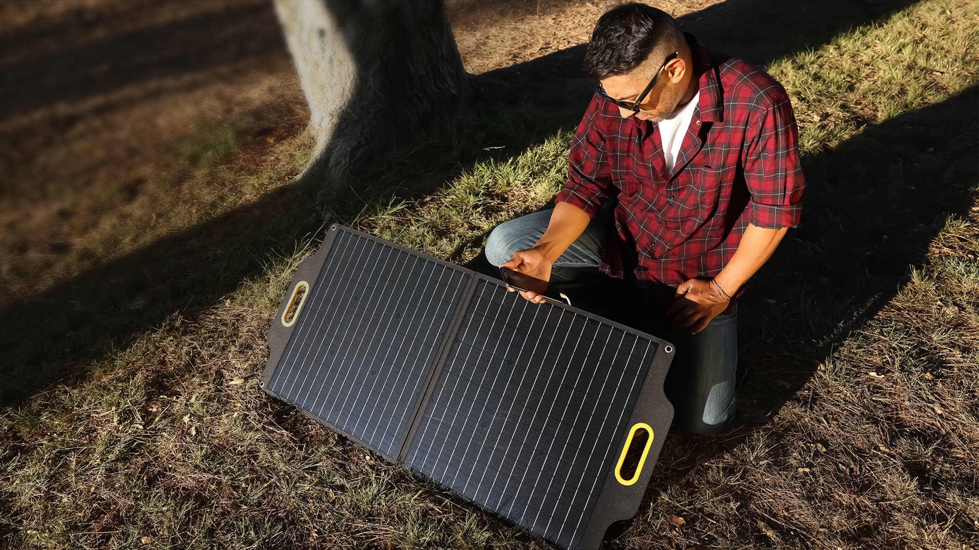 Powerness S80 Solar Panel: Man outdoors connecting cellphone to the solar panel using the USB-C cord option